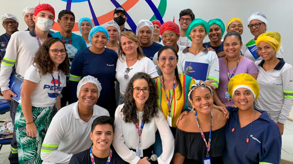 Colaboradores em pequenos grupos discutindo situações reais de comunicação entre turnos