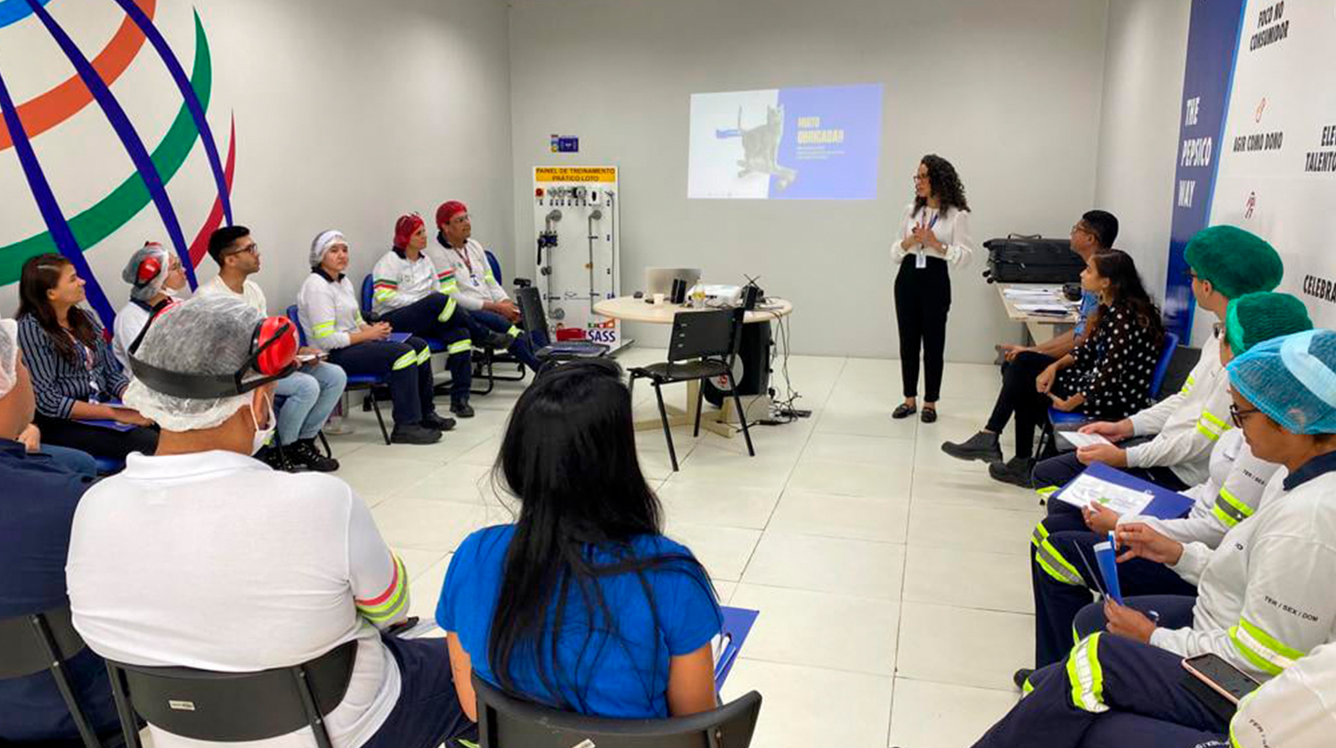 Time de operadores da PepsiCo reunidos em círculo durante encontro de comunicação assertiva na linha de frente