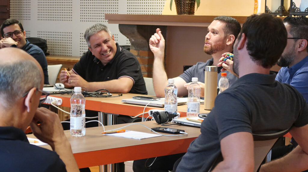 Foto de colaboradores aprendendo a jogar o  game corporativo presencial Monta Bike da Destrava.