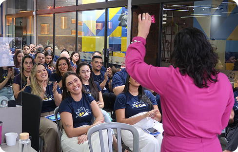 pessoas sentadas presenciando uma aula com temática de dinâmica corporativa
