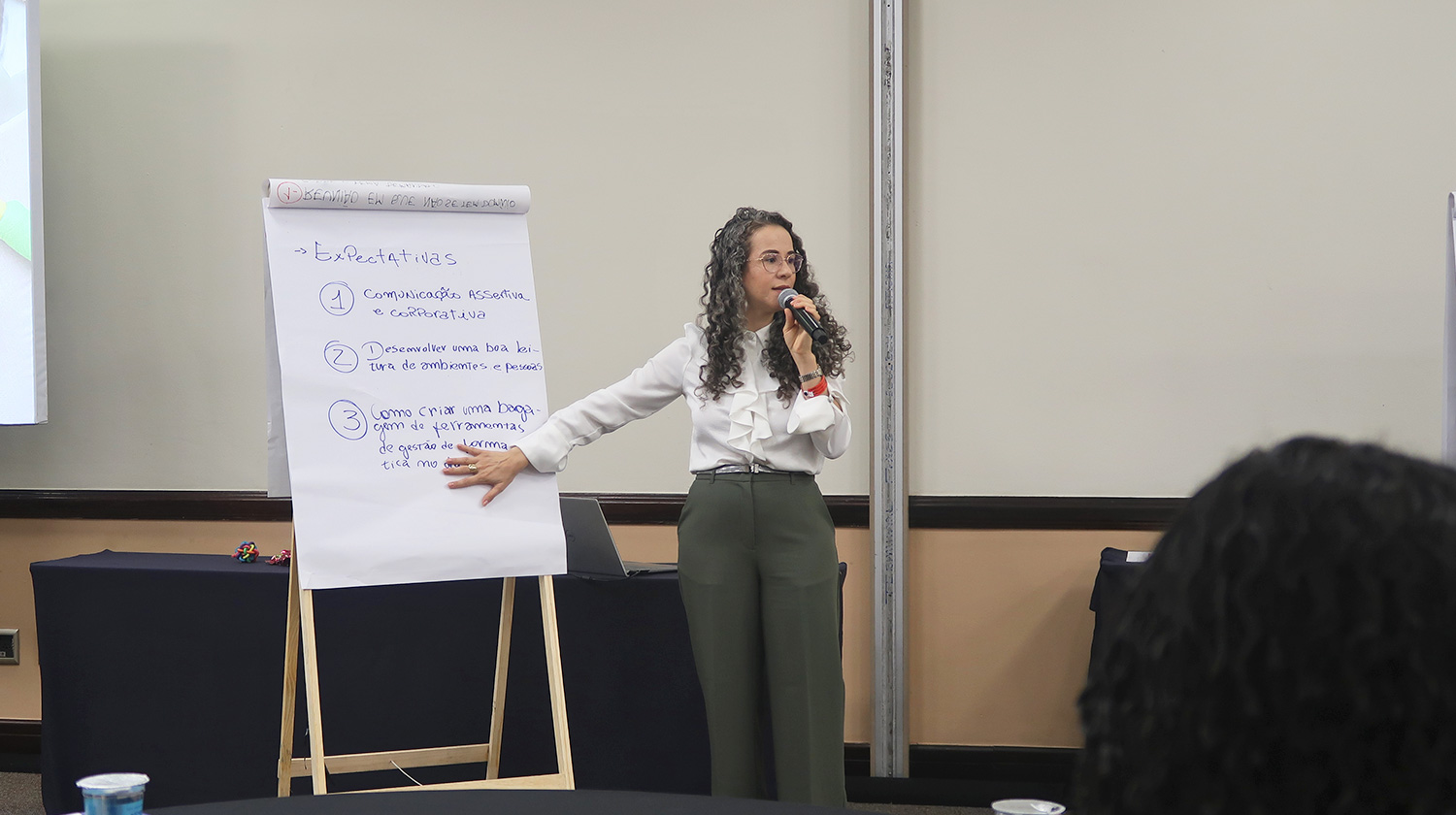 Facilitadora Flávia Strombeck da Destrava conduzindo dinâmica com trainees da Aegea durante encontro presencial.
